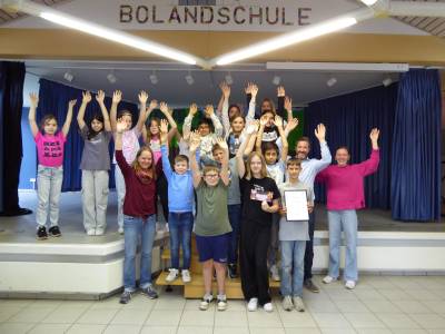 An der Bolandschule in Herzebrock jubelte die stellvertretende Schulleiterin Svenja Hunke, Brgermeister Marco Diethelm und Klimaschutzmanagerin Caroline Httemann mit den Kindern der Erdmnnchenklasse ber die tolle Leistung beim Schulradeln. 